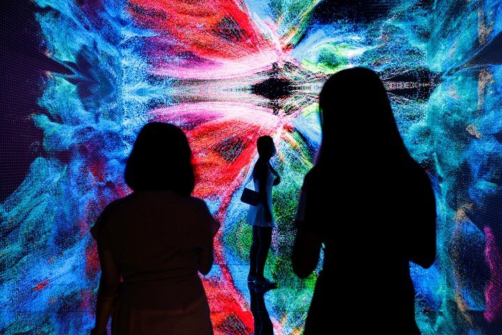 Visitantes delante de una instalación de arte inmersivo titulada "Machine Hallucinations - Space: Metaverso" del artista multimedia Refik Anadol, que se convertirá en NFT y se subastará en línea en Sotheby's, en la Feria de Arte Digital, en Hong Kong, China, el 30 de septiembre de 2021. REUTERS/Tyrone Siu 