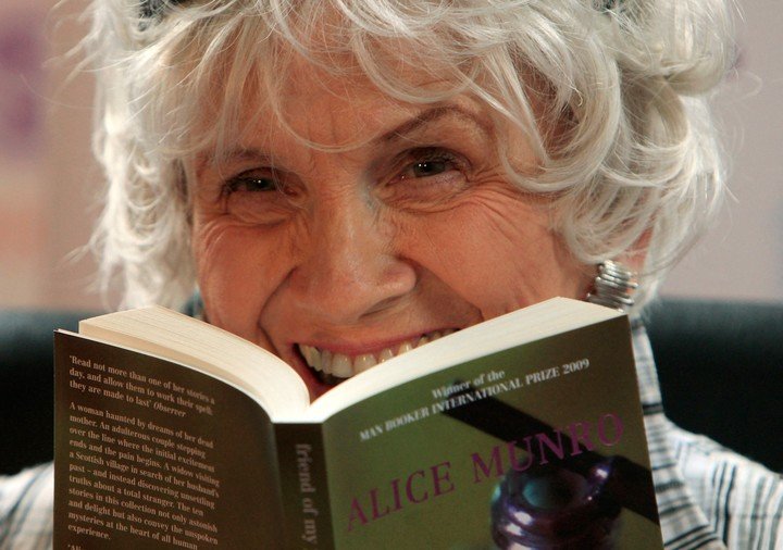(ARCHIVO) La escritora canadiense Alice Munro sostiene uno de sus libros mientras recibe su premio Man Booker International en el Trinity College de Dublín, en Dublín, Irlanda, en 2009. (Foto de PETER MUHLY / AFP)