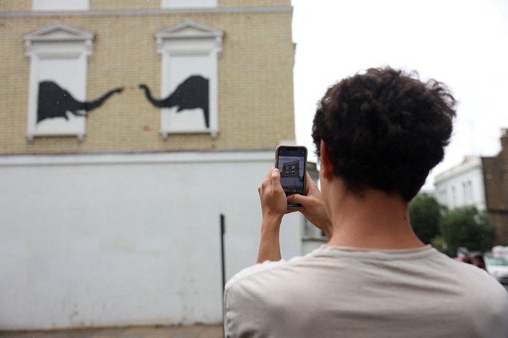 Yuval Weiss toma una foto de la nueva obra de arte del artista británico Banksy, en Fulham, Londres, Gran Bretaña, 6 de agosto de 2024. REUTERS/Mina Kim