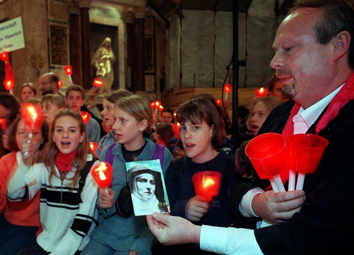 Jovenes de la diocesis de Colonia, Alemania, cantan en el antiguo templo panteonico romano, mientras una persona no identificada muestra un panfleto sobre la canonizacion de la hermana Edith Stein, sabado 10 de octubre de 1998. [AP photo-Pier Paolo Cito]