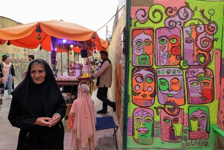 Visitantes en el taller del artista iraní Adel Yazdi. Foto: ATTA KENARE / AFP