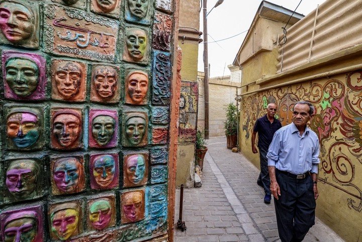 Visitantes en el taller del artista iraní Adel Yazdi. Foto: ATTA KENARE / AFP