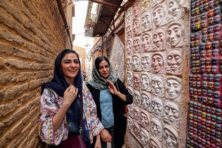 Visitantes en el taller del artista iraní Adel Yazdi. Foto: ATTA KENARE / AFP