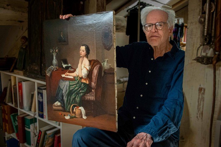 Horacio Amigorena en su casa con la pintura donada.
Foto: Noel Smart