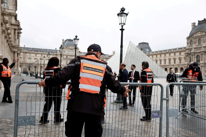 Empleados de seguridad instalan barreras cerca de la pirámide de cristal del Museo del Louvre, cerrado al día siguiente de un espectacular robo. REUTERS/Benoit Tessier/Foto de archivo