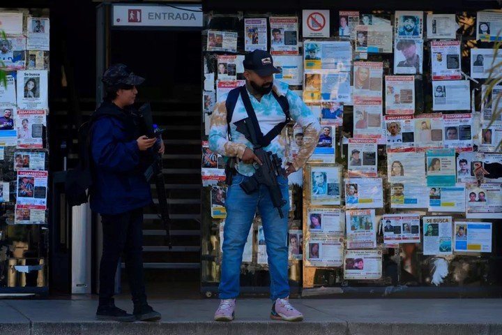 Agentes de policía, delante de una pared cubierta con carteles con el rostro de desaparecidos, frente a la Fiscalía Especializada en Investigación de los Delitos de Desaparición Forzada, en Guadalajara, México, el 25 de febrero de 2026. (Marco Ugarte/AP)